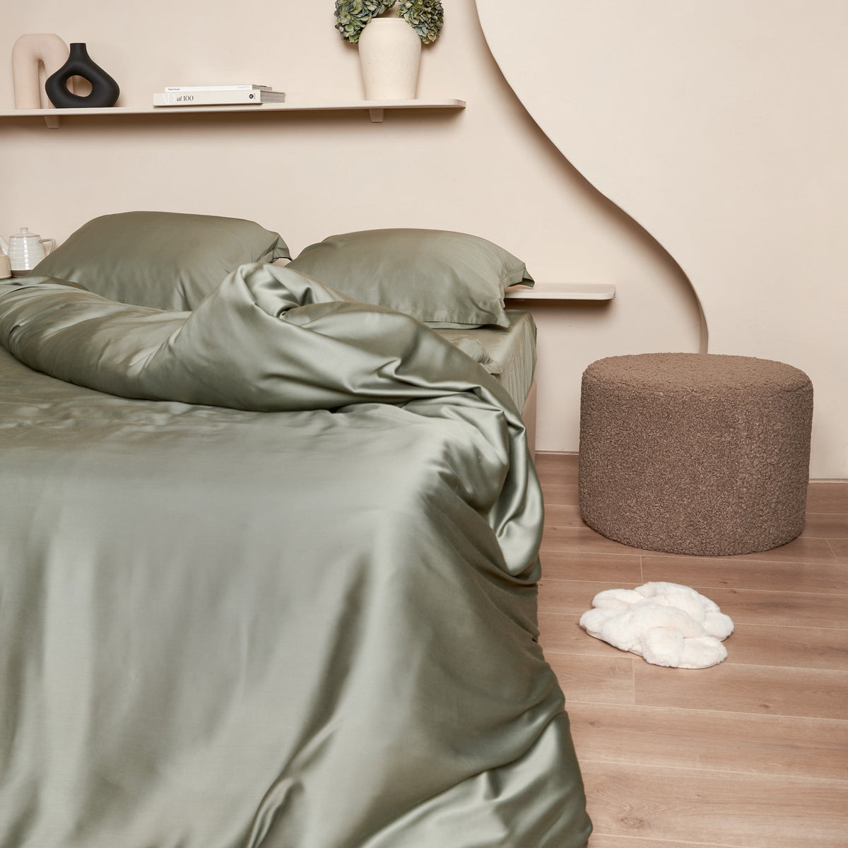 Opgemaakt bed van Bamboe beddengoed in de kleur olijfgroen. Hoekje van het hoeslaken zichtbaar door opengeslagen bed.